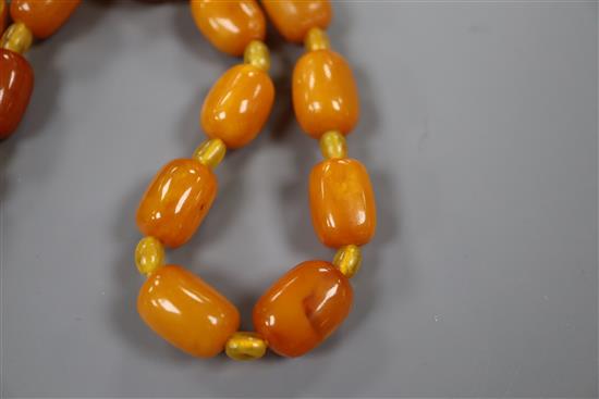 A single strand barrel shaped amber bead necklace, 124cm, gross weight 75 grams.